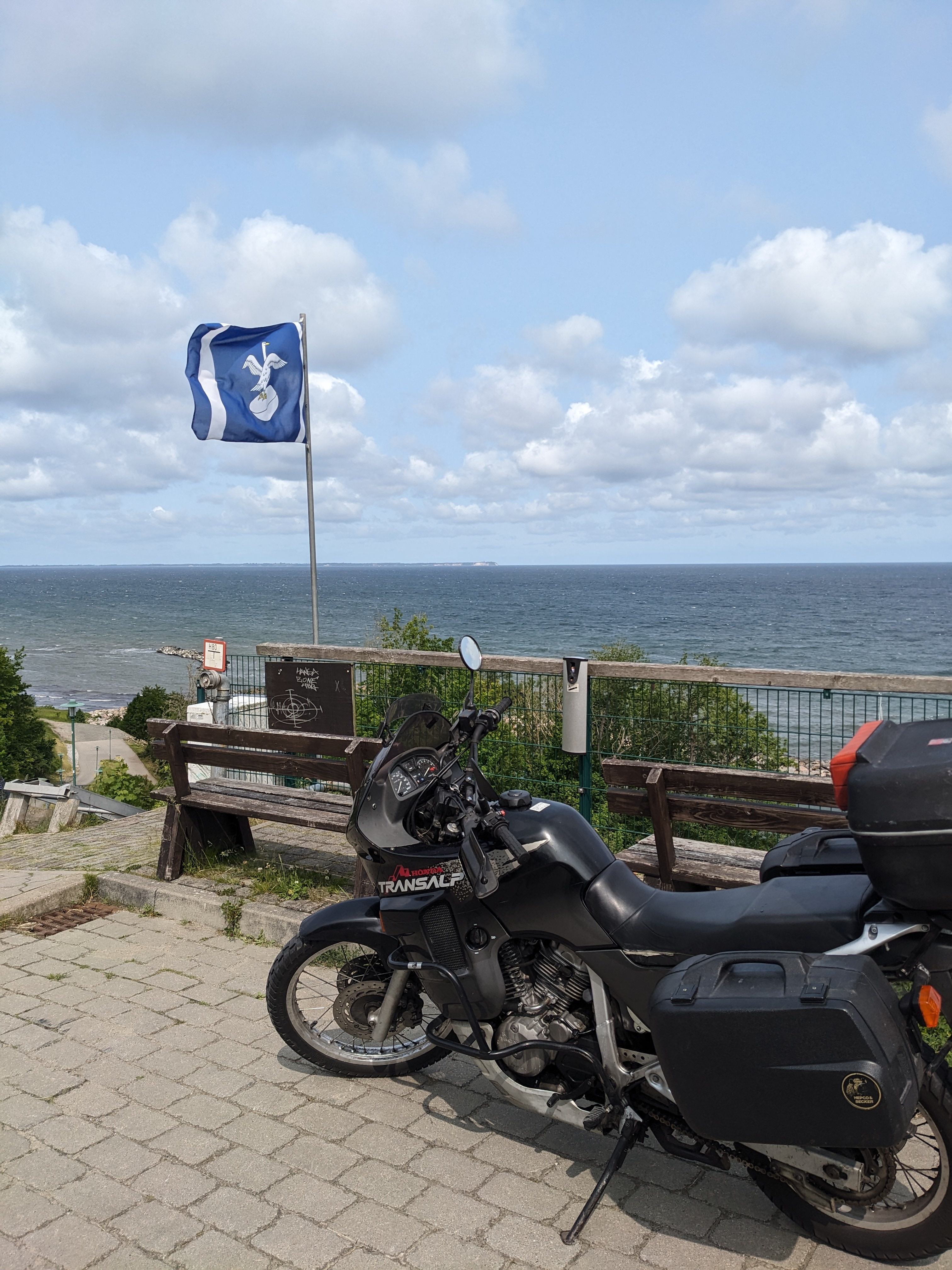 a honda transalp motorcycle next to the flag of the island Rügen